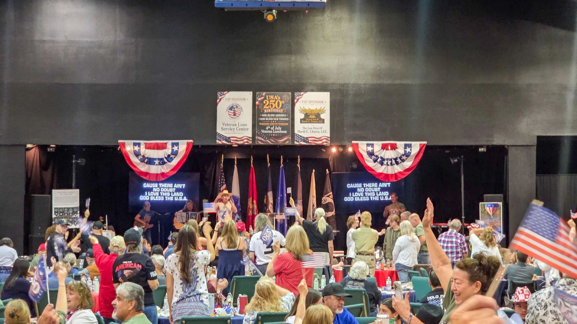 Crowd waving flags at the 4th of July Veterans Luncheon